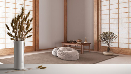 White table top or shelf with straws, dry plants, ornament, ears, sheaf, branch in vase, over zen meditation room with carpet and pillows, modern minimal interior design