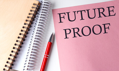 FUTURE PROOF word on the pink paper with office tools on white background