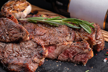 Meat steak medium, on a board with a stone and a bottle of wine