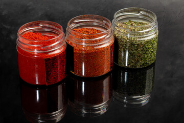 Variety of spices on a dark background in a glass bowl. Enhancement of taste.