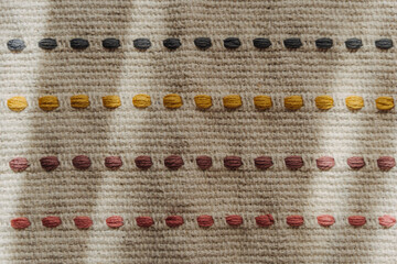 Modern hand woven cotton carpet with tassel element. Rug texture with stripes pattern. Natural threads. Scandi or boho style.