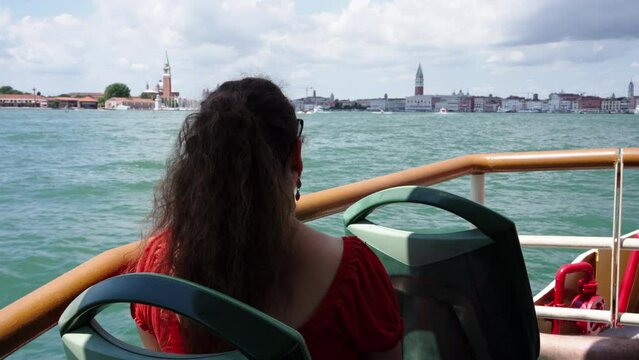 Woman tourist traveling on water ferry on Venice's Grand Canal.