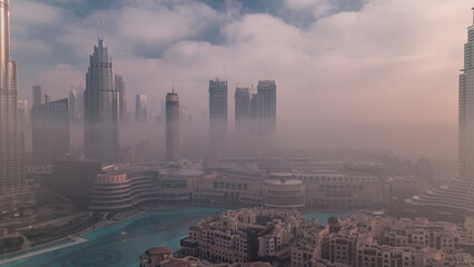 Aerial view morning fog covered Dubai International Financial Centre district timelapse