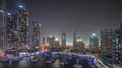 Fototapeta na wymiar Panorama showing Dubai marina tallest skyscrapers and yachts in harbor aerial night timelapse.