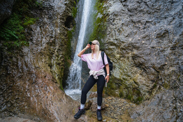 Girl trekker in the Tatra mountains at the Siklawica waterfall in summer.