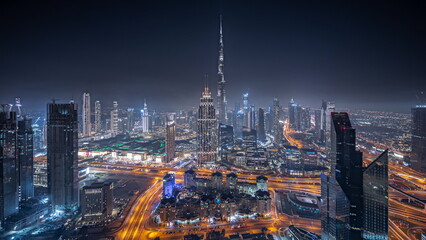 Panorama showing aerial view of tallest towers in Dubai Downtown skyline and highway night...