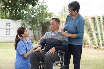 Nurse caring Asian senior man on wheelchair outdoor at hospital. Asian nurse taking care patient senior man on wheelchair