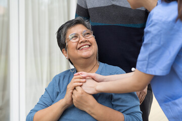 Happy smiling Asian patient elderly woman sitting on wheelchair. Nurse caring Asian older woman on wheelchair outdoor at hospital. Asian nurse taking care patient old woman on wheelchair with kindly