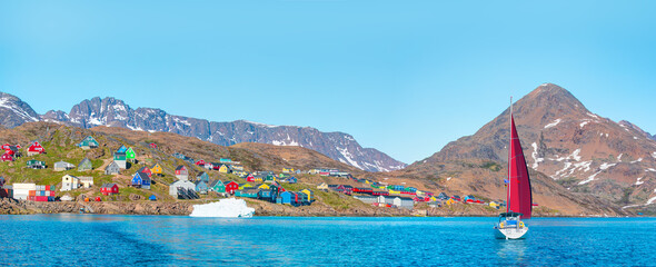 A yacht with red sails sailing on the sea - Picturesque village on coast of Greenland - Colorful...