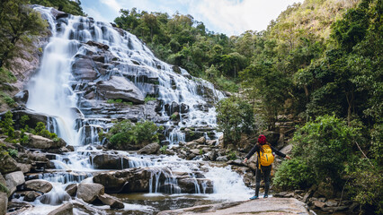Women travel relax waterfall. In the winter. at the waterfall mae ya chiangmai in thailand. Natural background waterfall. travel nature.
