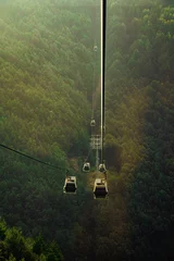 Zelfklevend Fotobehang view of cable car in the mountains at golden hour © Sami