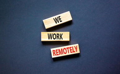 We work remotely symbol. Concept words We work remotely on wooden block. Beautiful black table black background. Business we work remotely concept. Copy space.