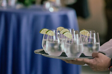 verres d'eau avec tranche de lime sur un plateau de service à un événement