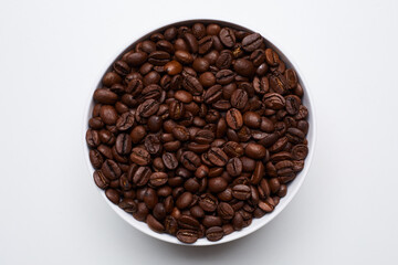 Fototapeta premium roased coffee beans in bowl on white background. Still Photo