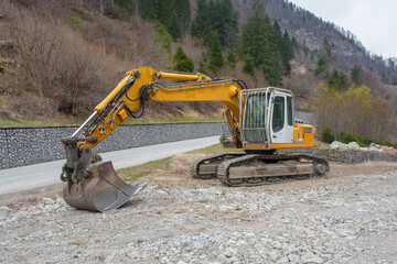 A crawler excavator with a rotating house platform and continuous caterpillar track, and a scoop...