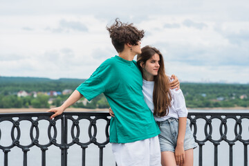 couple of young people hugging on the embankment above the river