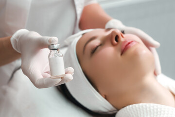 Naklejka premium Woman beautician showing cosmetic product