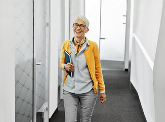 business businesswoman senior elderly office meeting woman portrait corporate manager smiling walking hallway corridor happiness mature glasses career job break executive