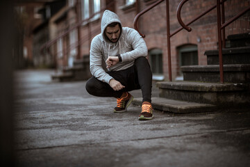 Young man resting after jogging and exercising in the city