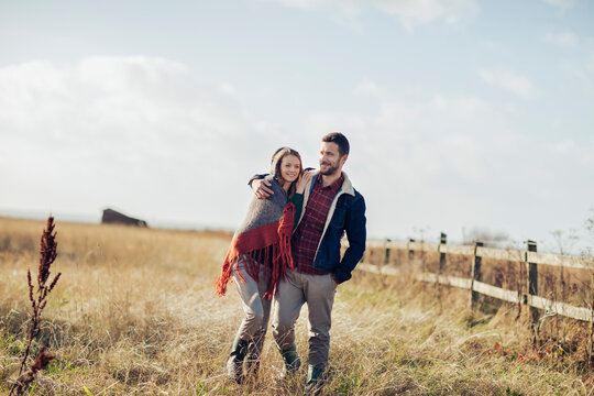 Young couple walking on a field in the countryside