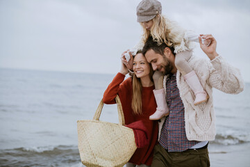 Young family walking on a beach during winter