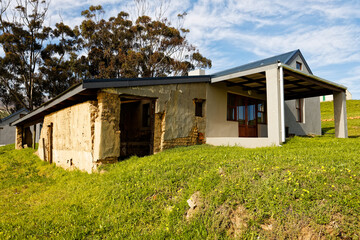 A modern farmhouse connected to a very old, dilapidated building on a farm near Caledon, Western Cape, South Africa.