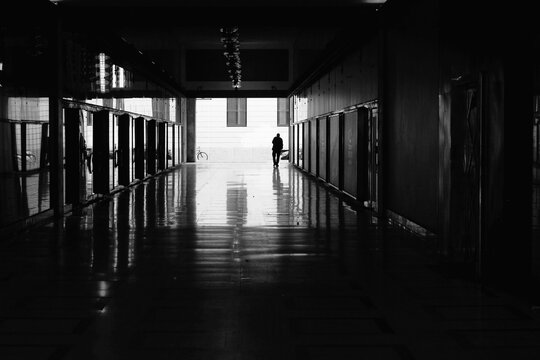 silhouettes of a man in an underpass in the historic center of milan - street photography in black and white.