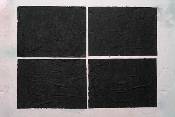 Four sheets of black paper with folds.