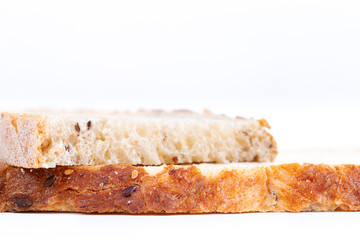 Two pieces of homemade loaf bread on white background. Bread is gluten-free and has seeds. It has many alveoli. Horizontal .