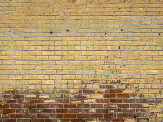 old rough brickwork wall with yellow paint