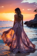 Seductive blonde woman in sexy dress posing on the beach in sunset light. Perfect wavy hairs, tan skim body. Summer tropical mood. View from back.