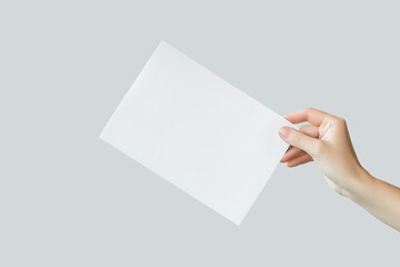 female hand holding blank white a5 poster isolated on gray background