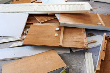 demolition byproducts, lumber, broken furniture and planks lying on the floor of a room