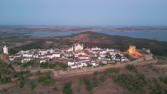Aerial footage of the Monsaraz Castle on a hill at sunset, Portugal