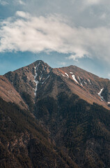 mountains with cloudy sky next to a lake