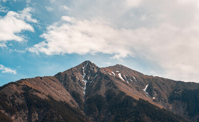 mountains with cloudy sky next to a lake