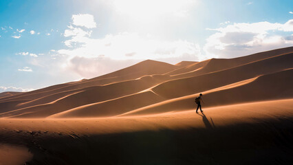 Fototapeta na wymiar hiker between desert dunes