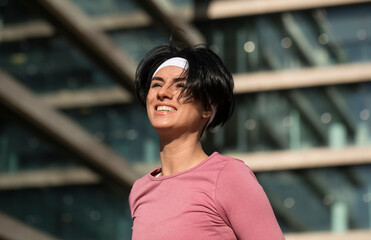 Close-up shot of a beautiful sportswoman looking at the camera. She is tired after intensive...