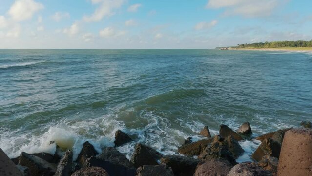 Big Waves Breaking Against Northern Pier at Liepaja Karosta, Latvia in Sunny Day, Slow Motion Medium Shot. Karosta Northern Forts on the Beach of Baltic Sea