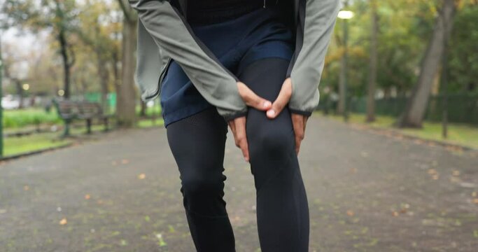 Closeup, person and injury of knee pain for fitness, first aid emergency and exercise health risk at park. Legs of athlete, accident and workout mistake with injured muscle, orthopedic care and wound