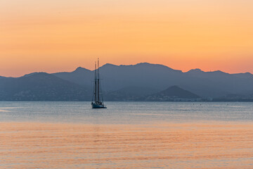 Un voilier devant un coucher de soleil
