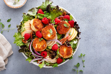 Fried goat cheese salad with apples and raspberries and vinaigrette dressing