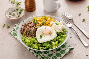 Breakfast bowl with quinoa, herbed corn, feta cheese and fried egg