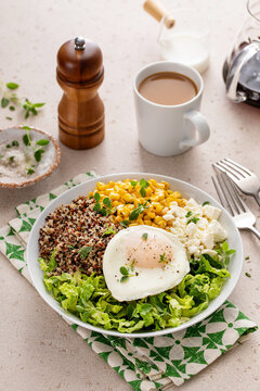 Breakfast bowl with quinoa, herbed corn, feta cheese and fried egg