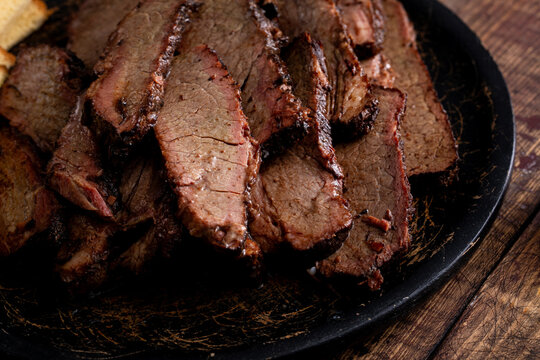 Sliced smoked brisket on a serving plate with toast