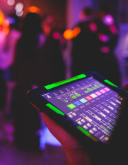 View of lighting technician with tablet, operator controlling sound and light during live event...