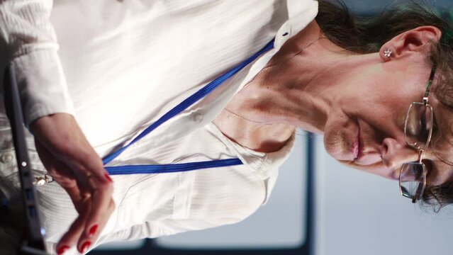 Vertical video Senescent admin in high tech facility equipped to handle modern computing requirements, doing regular upgrades to blade servers, increasing processing power and storage capacity to