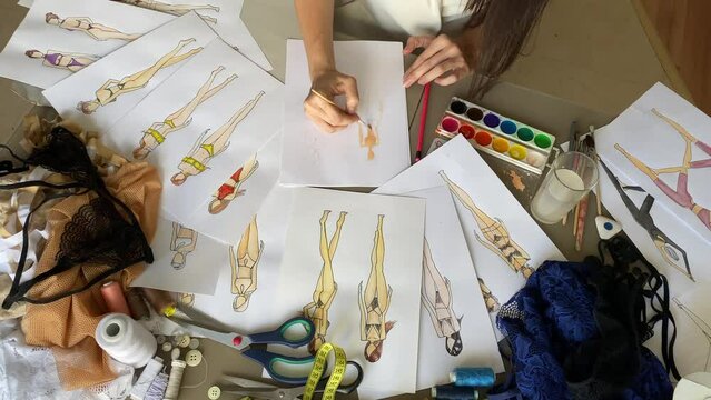 A woman draws sketches of swimwear and underwear. Timelapse. 