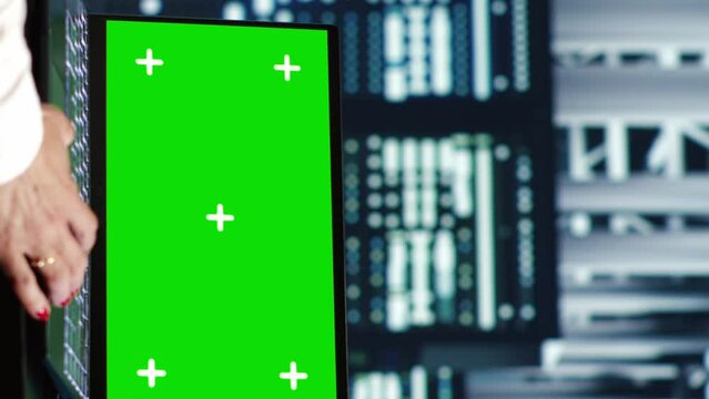 Vertical video Experienced IT developer in server farm housing high end racks capable of quickly and efficiently performing complex computations and data analysis, using mockup laptop to patch up bugs