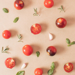Creative arrangement of cherry tomatoes, basil, rosemary, garlic, wild oregano. Minimal food concept. Flat lay